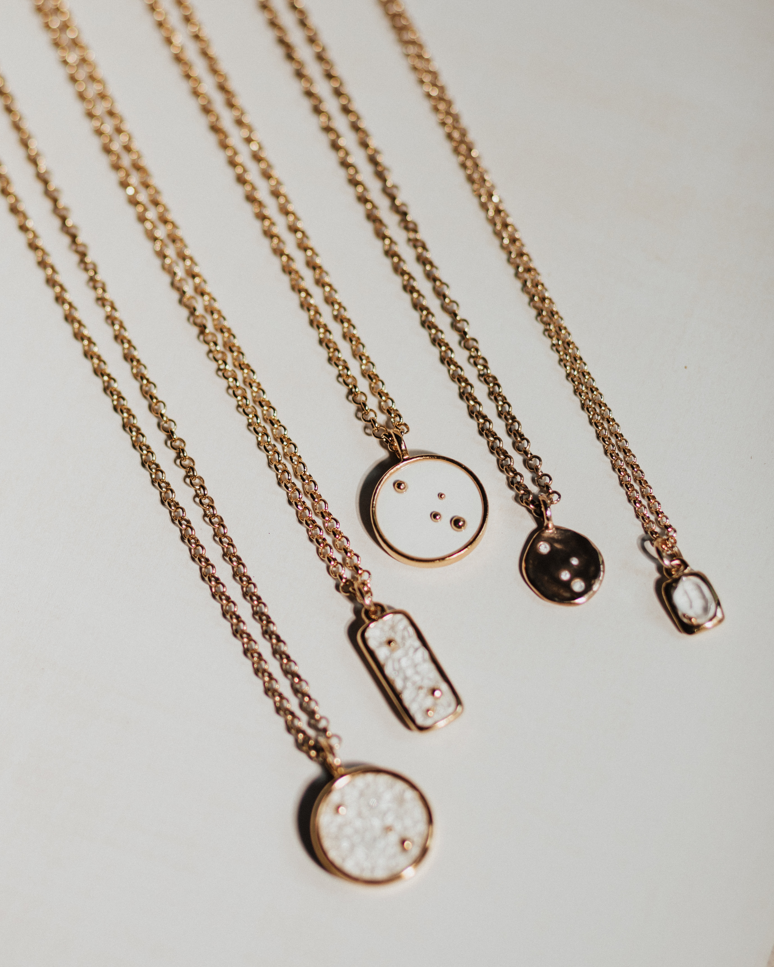 Pluma necklaces arranged in flat lay