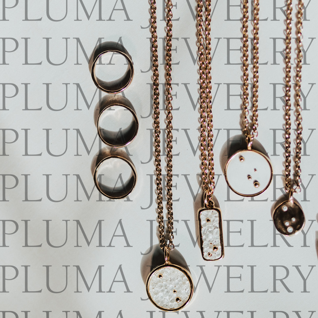 Pluma Jewelry necklace and rings flatlay branded graphic
